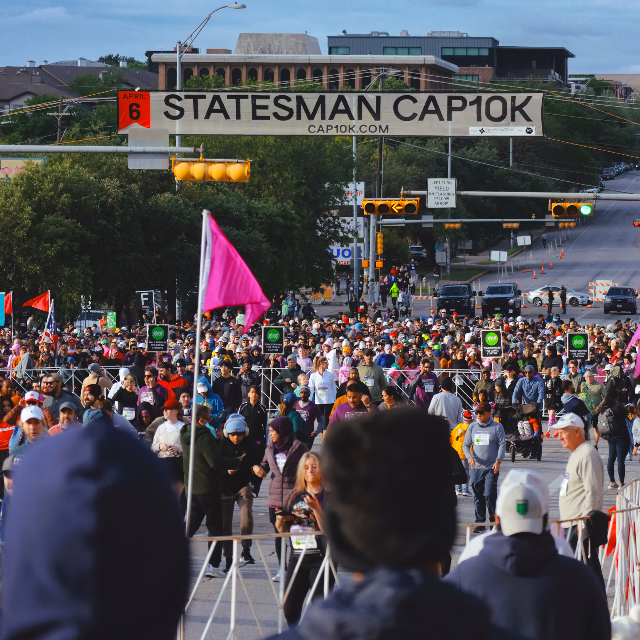 Local community fundraiser event with volunteers, charity booths, and smiling participants outdoors.